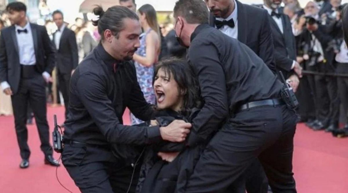 Topless woman protesting against sexual violence in Ukraine, shouting ‘stop raping us’ on the Cannes red carpet